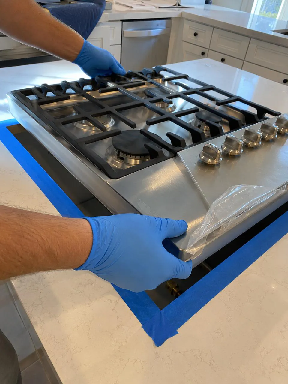 Technician servicing stainless gas cooktop in Southern California home