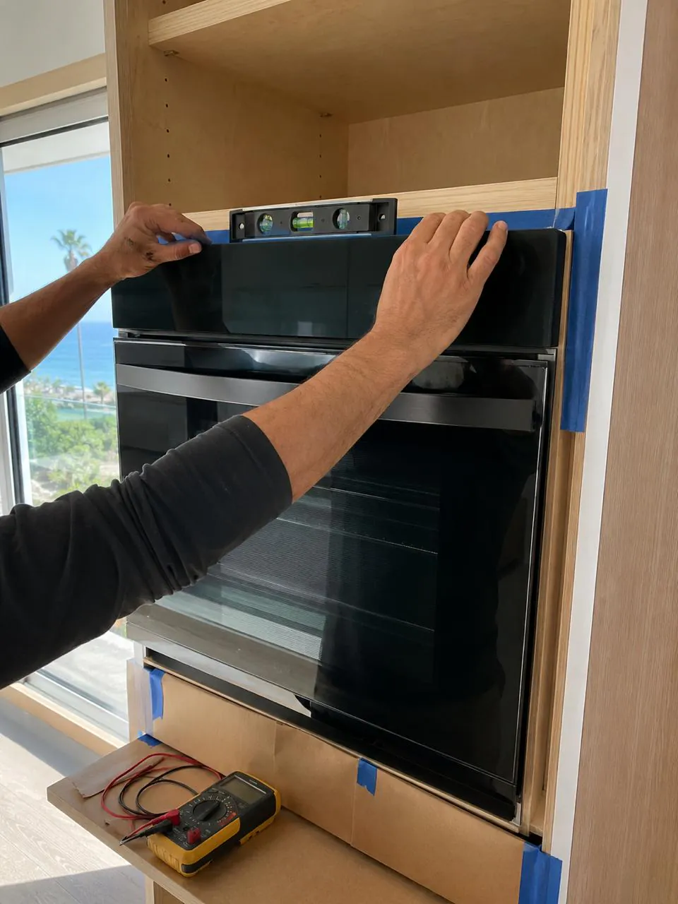 Technician leveling built-in wall oven in Southern California home