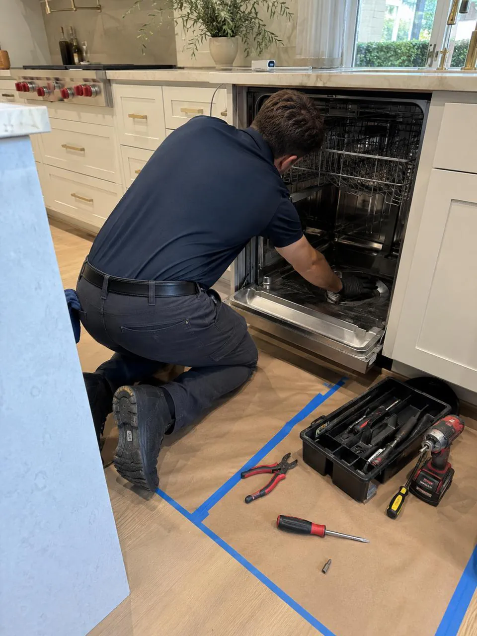 Technician repairing a built-in dishwasher in a San Diego kitchen